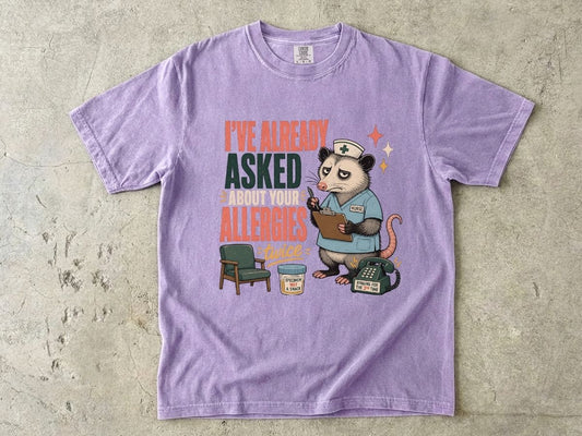 T‑Shirt — "I've Already Asked About Your Allergies Twice" Nurse Possum Graphic
