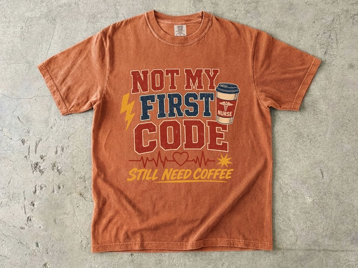 "Not My First Code, Still Need Coffee" bold retro Comfort Colors tee. Funny ER/ICU nurse gift shirt.