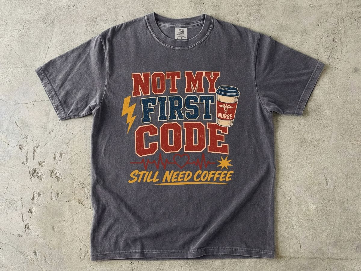 "Not My First Code, Still Need Coffee" bold retro Comfort Colors tee. Funny ER/ICU nurse gift shirt.