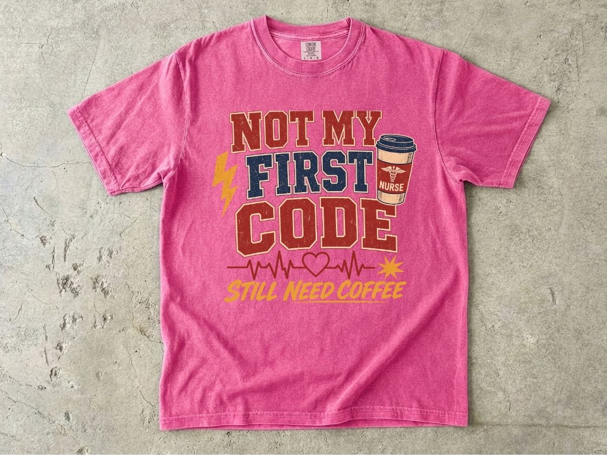 "Not My First Code, Still Need Coffee" bold retro Comfort Colors tee. Funny ER/ICU nurse gift shirt.