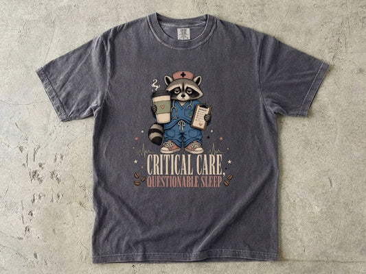 T‑Shirt — "Critical Care, Questionable Sleep" Raccoon Nurse Graphic Tee